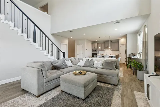 a living room with furniture kitchen view and a large window