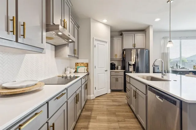 a kitchen with stainless steel appliances granite countertop a sink and a refrigerator