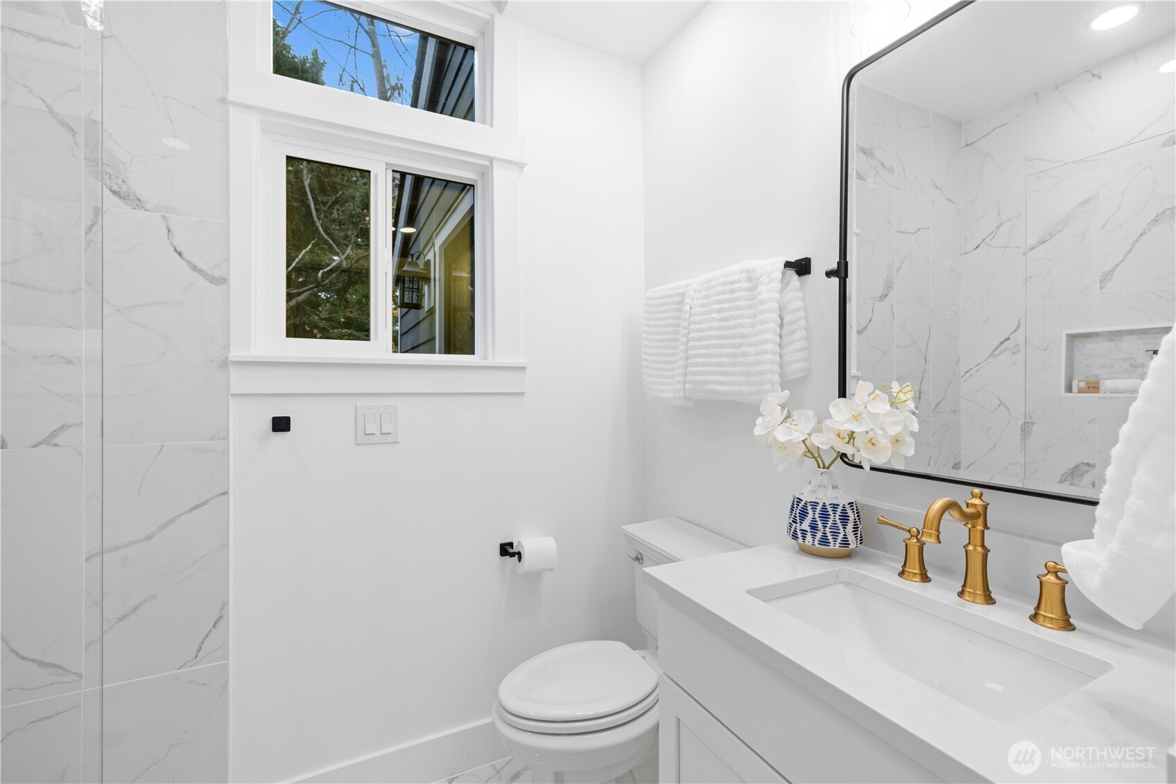 1014 4th Avenue North Seattle, WA 98109 - Photo 30 of 40 a bathroom with a toilet a sink a mirror and shower