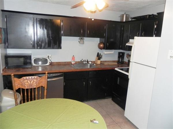 130 8 Briarcliff Road, Unit 1 Raynham, MA 02767 - Photo 3 of 13 a kitchen with a sink a refrigerator and cabinets
