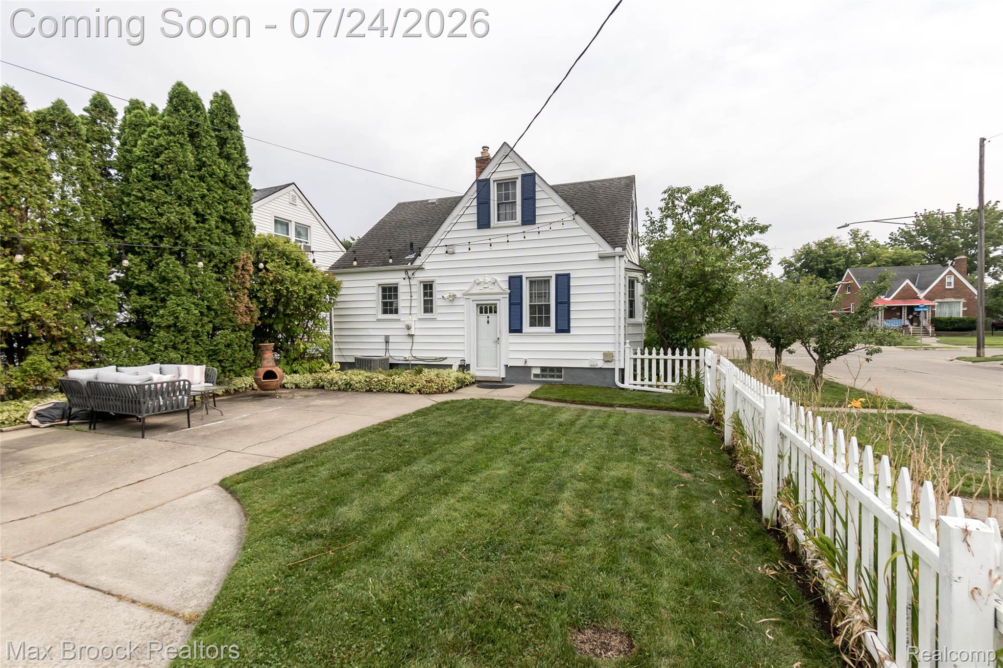 1090 Cambridge Road Berkley, MI 48072 - Photo 33 of 43 White siding residence featuring a dark shingle roof, blue window shutters, and a white picket fence