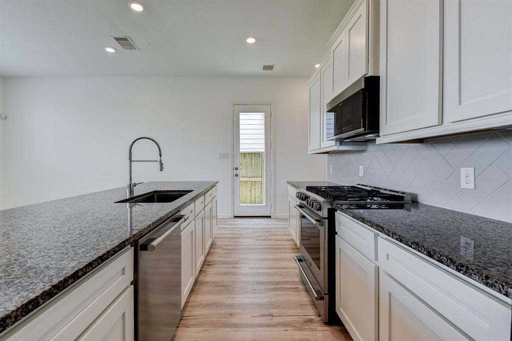 4115 Balboa Drive Iowa Colony, TX 77583 - Photo 6 of 9 a kitchen with granite countertop a sink and a stove top oven