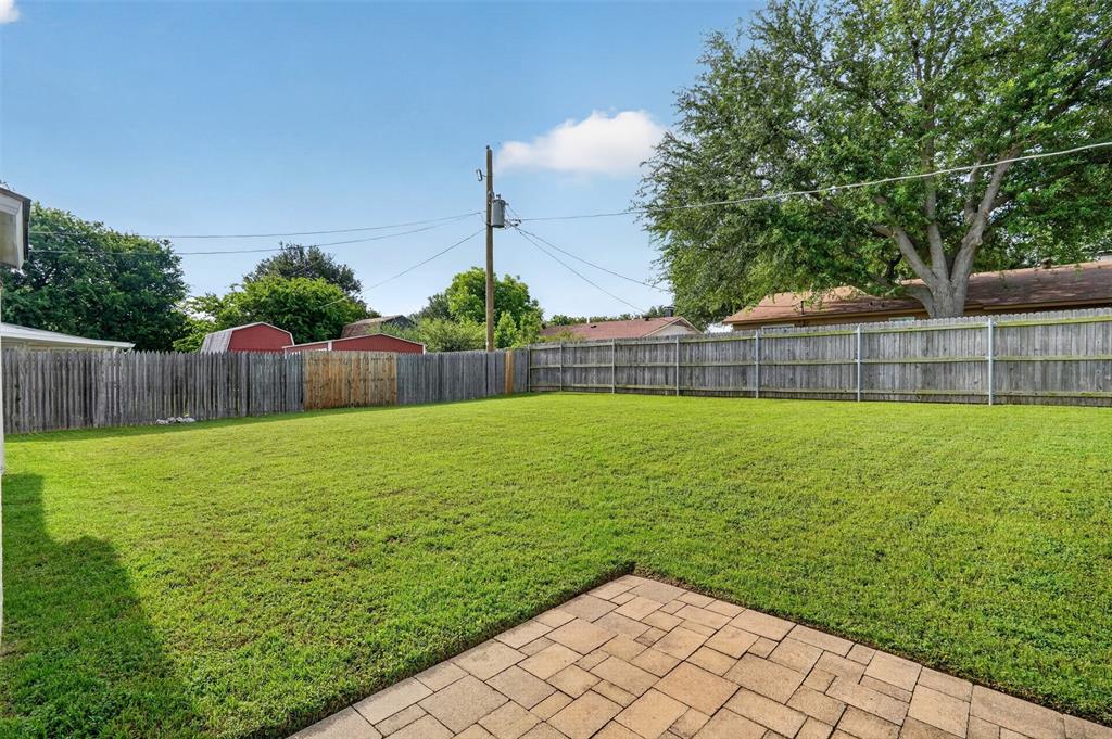1212 Manning Road Benbrook, TX 76126 - Photo 15 of 20 Expansive backyard featuring a lush green lawn, full privacy fencing, and a paver patio