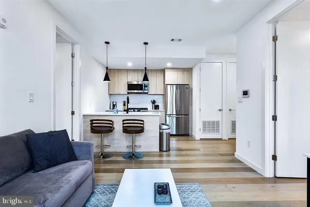 a kitchen with stainless steel appliances a stove a refrigerator and a white cabinets