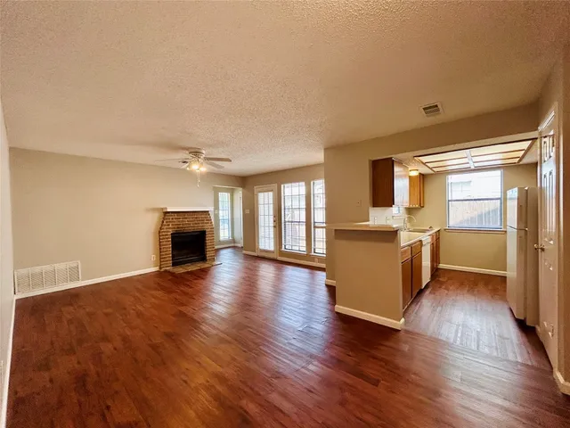 a view of empty room with wooden floor and fireplace