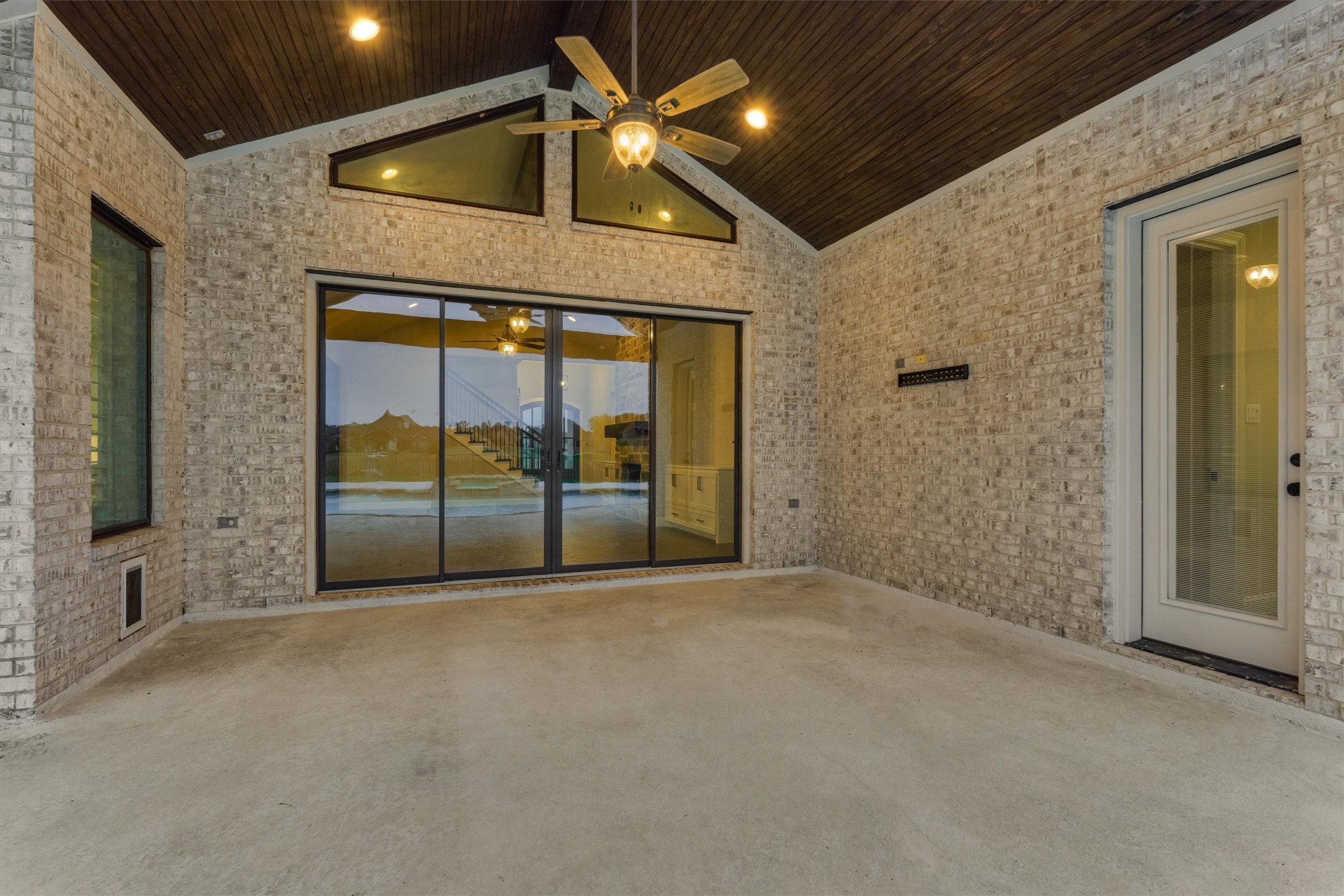 11618 Renaissance Drive Montgomery, TX 77356 - Photo 36 of 49 The back porch offers a vaulted ceiling accented with stained wood tongue-and-groove panels, creating a warm and inviting outdoor retreat. Add a cozy sitting area to fully enjoy the space. The door to the right provides convenient access to a full bath.