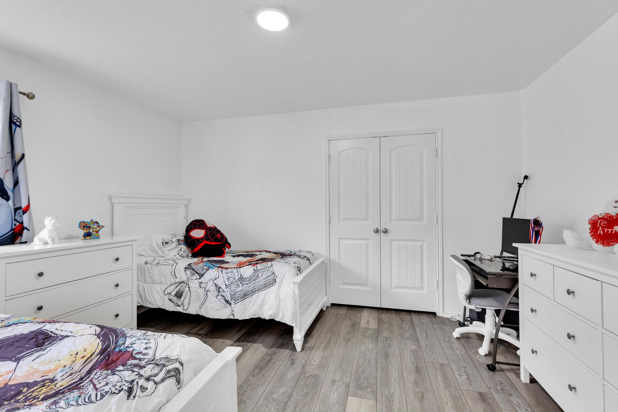 119 Beth Ann Loop Taylor, TX 76574 - Photo 18 of 31 Well-lit sleeping quarters with elegant wood-look flooring and ample storage space.