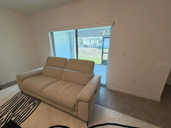 a blue couch sitting in a living room next to a window