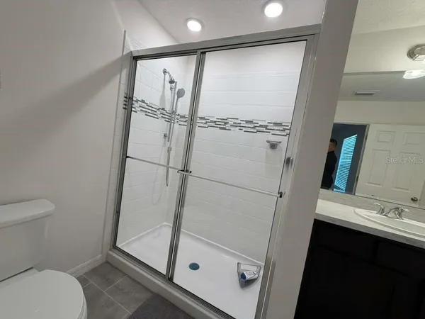 a bathroom with a sink a toilet and a mirror