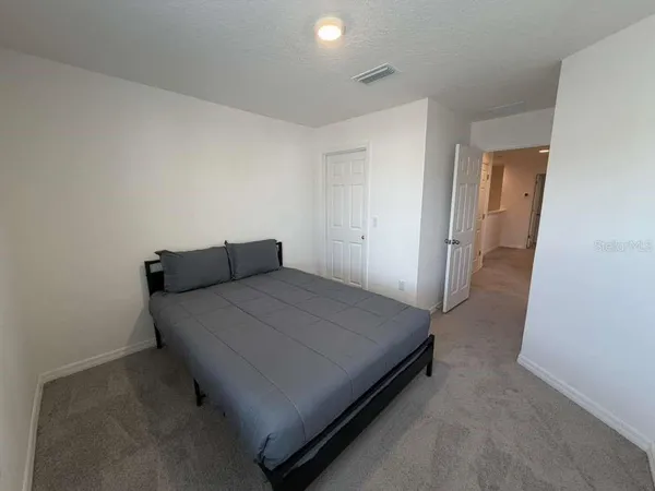 a bed sitting in a bedroom next to a window