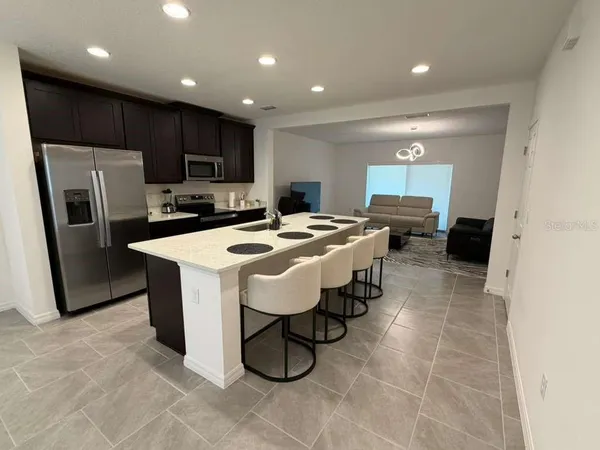 a kitchen with stainless steel appliances a refrigerator a sink a stove a microwave and island