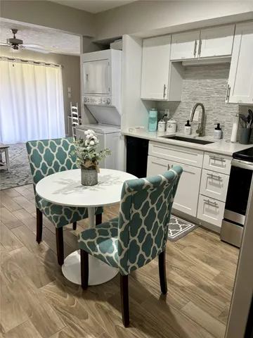 a kitchen with a table chairs and wooden floor