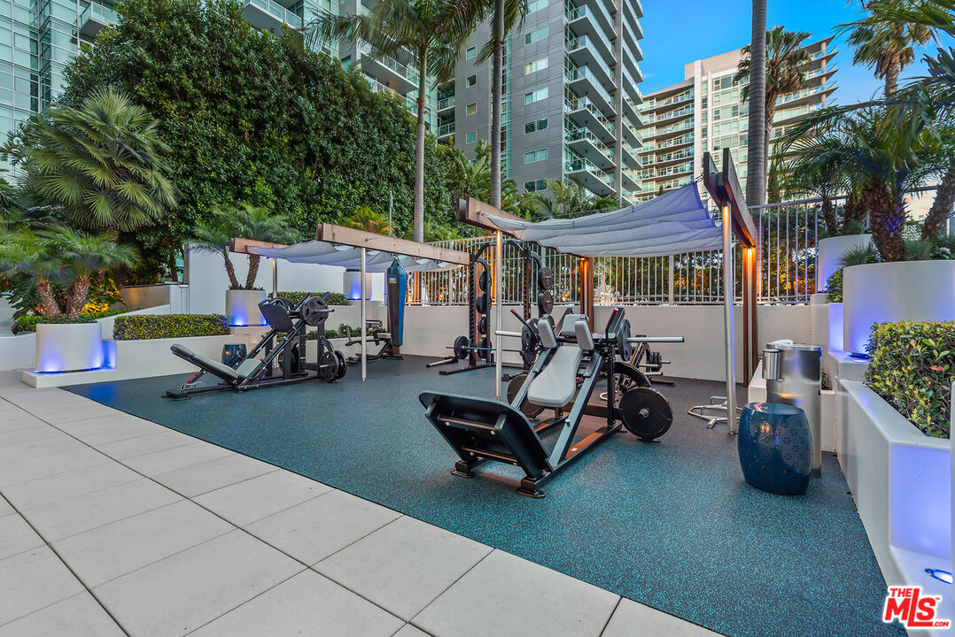 13700 Marina Pointe Drive, Unit 1520 Marina del Rey, CA 90292 - Photo 44 of 64 a view of a patio with table and chairs potted plants and a large tree