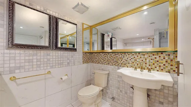 a bathroom with a sink a toilet and mirror