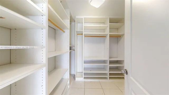 a view of walk in closet with empty racks