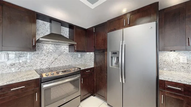 a kitchen with stainless steel appliances granite countertop a refrigerator and a stove