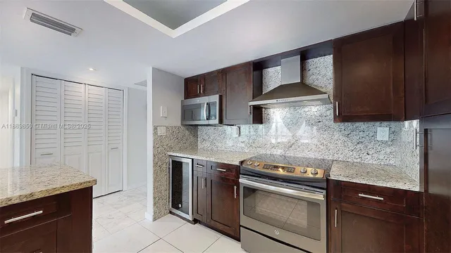 a kitchen with stainless steel appliances granite countertop a sink stove and cabinets