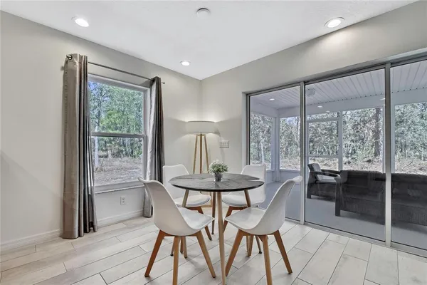 a dining room with furniture and large windows