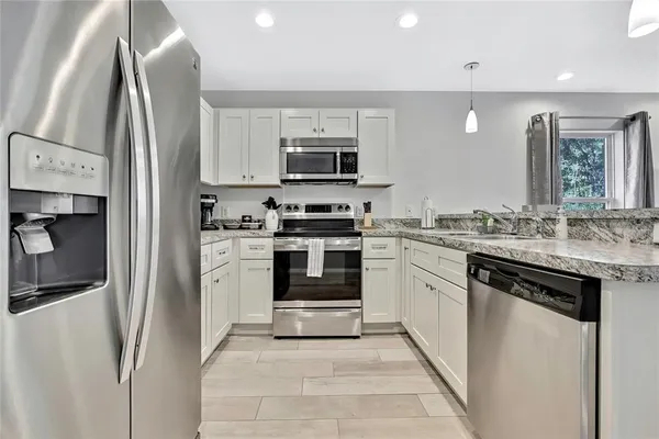 a kitchen with stainless steel appliances granite countertop a stove a sink and a refrigerator