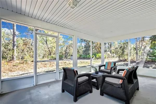 a living room with furniture and a floor to ceiling window