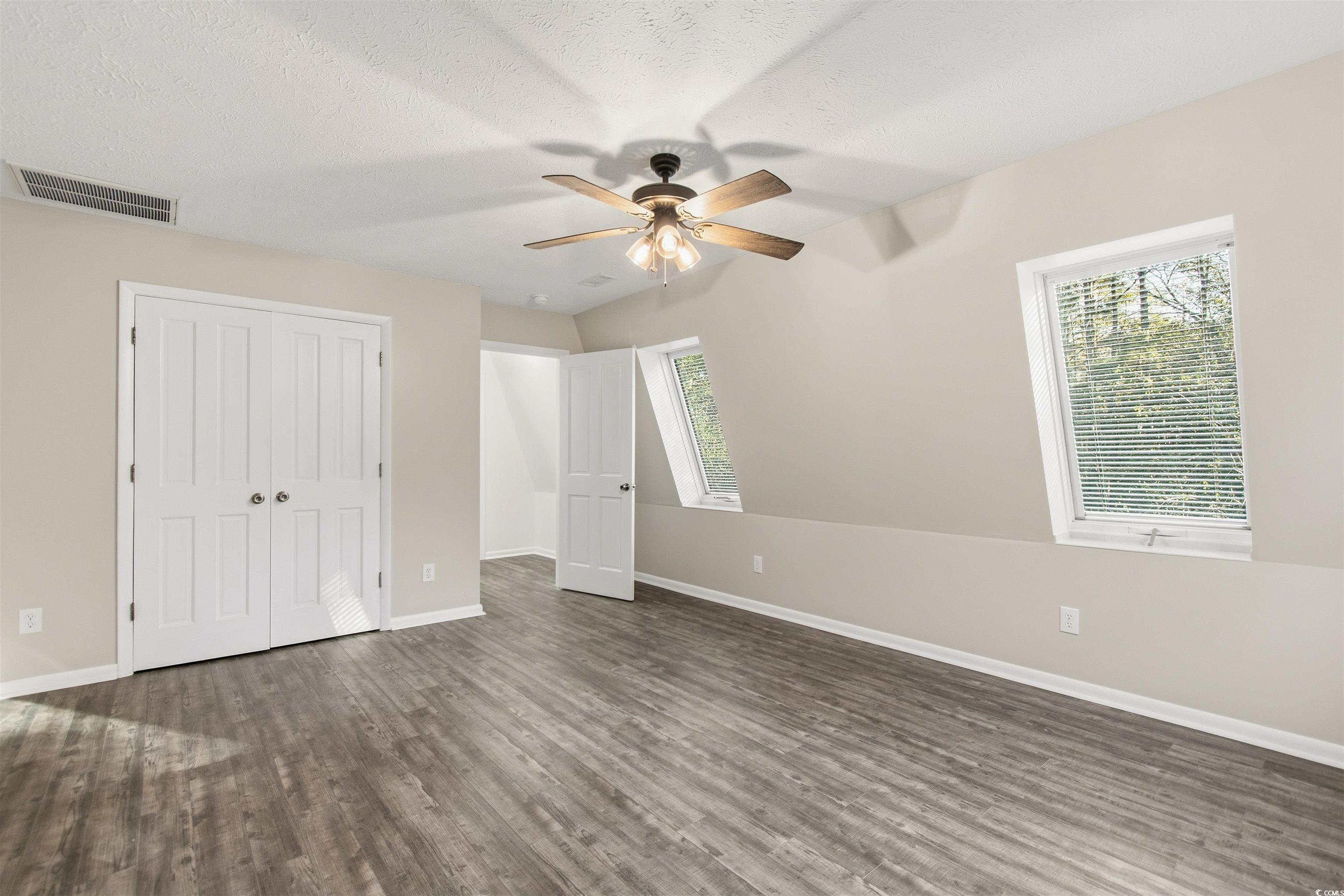 50 Irvin Enzor Road North Fair Bluff, NC 28439 - Photo 19 of 26 Upstairs #2 bedroom featuring a closet, wood finished floors, a ceiling fan, and a textured ceiling