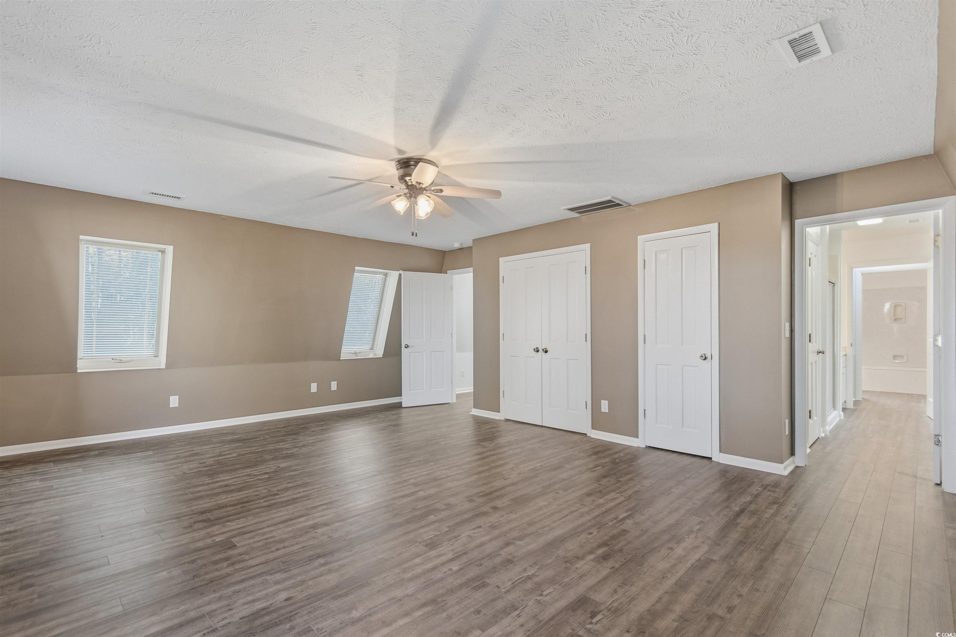 50 Irvin Enzor Road North Fair Bluff, NC 28439 - Photo 22 of 26 upstairs bedroom on the left with a textured ceiling, hard wood flooring, closets, and ceiling fan