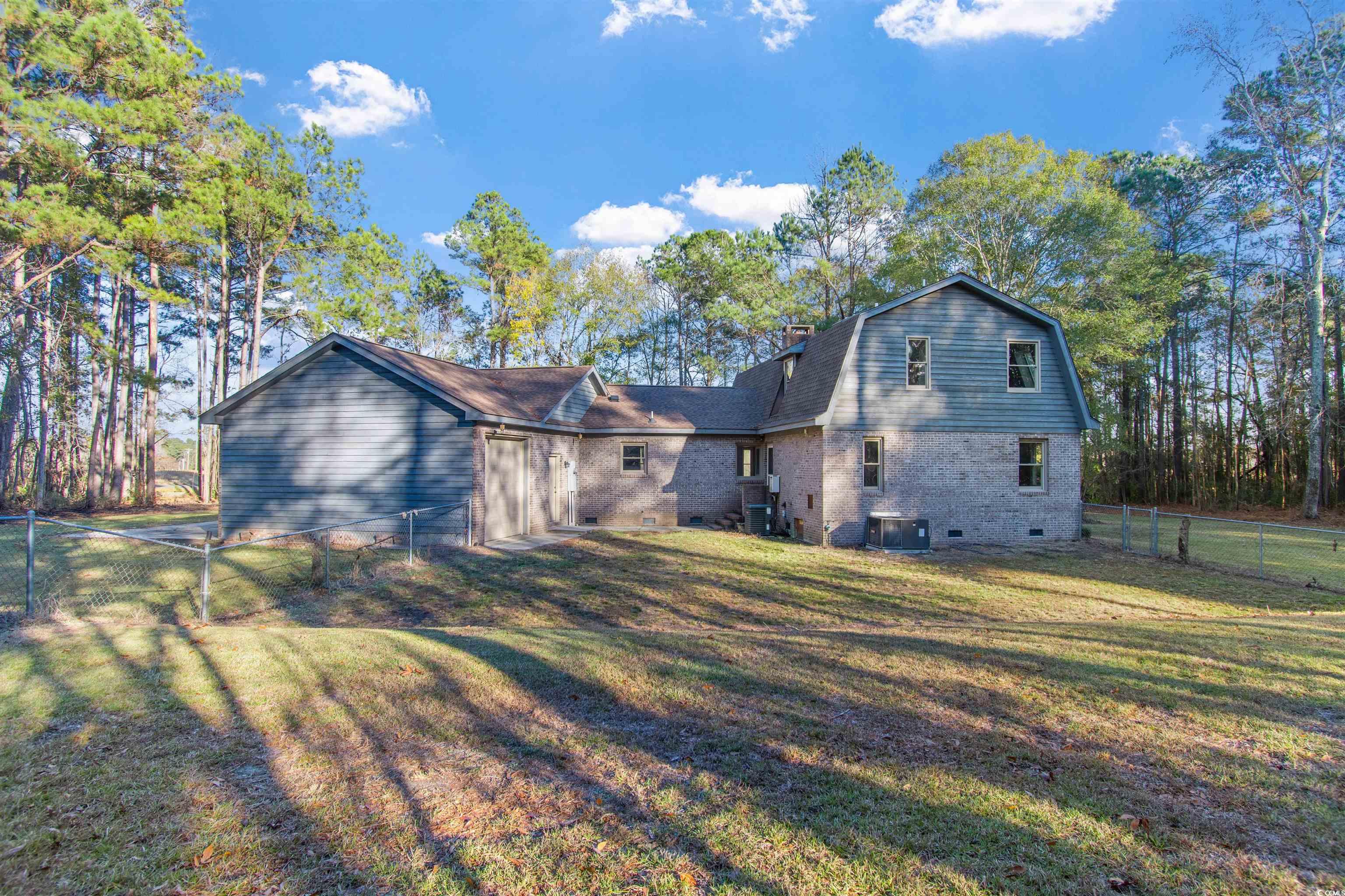 50 Irvin Enzor Road North Fair Bluff, NC 28439 - Photo 3 of 26 Rear view of property featuring a fenced backyard, a gambrel roof, brick siding, and crawl space