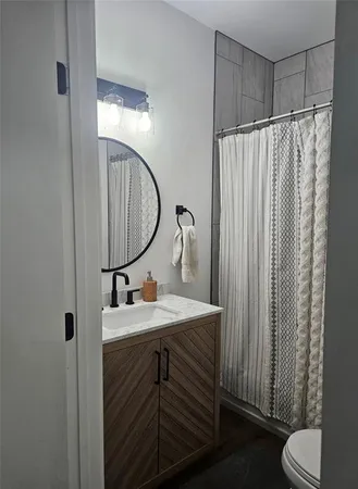 a bathroom with a sink toilet and mirror