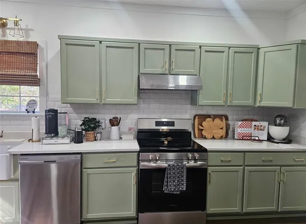 a kitchen with stainless steel appliances granite countertop a sink stove and cabinets
