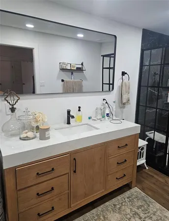 a bathroom with a granite countertop sink and a mirror