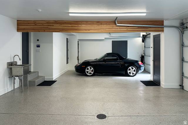 11454 South Oberland Road Sandy, UT 84092 - Photo 66 of 103 Two-car garage featuring an epoxy-coated concrete floor, stainless steel utility sink, and wood-finish ceiling beam
