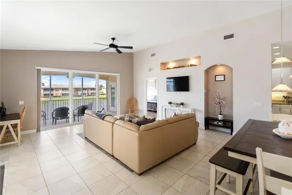 a living room with furniture a flat screen tv and a large window