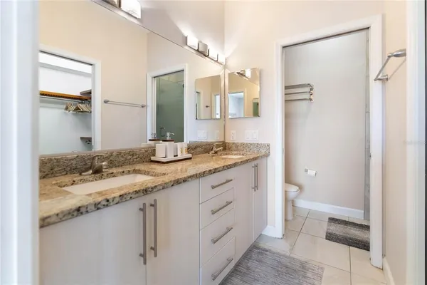 a bathroom with a granite countertop shower and a toilet