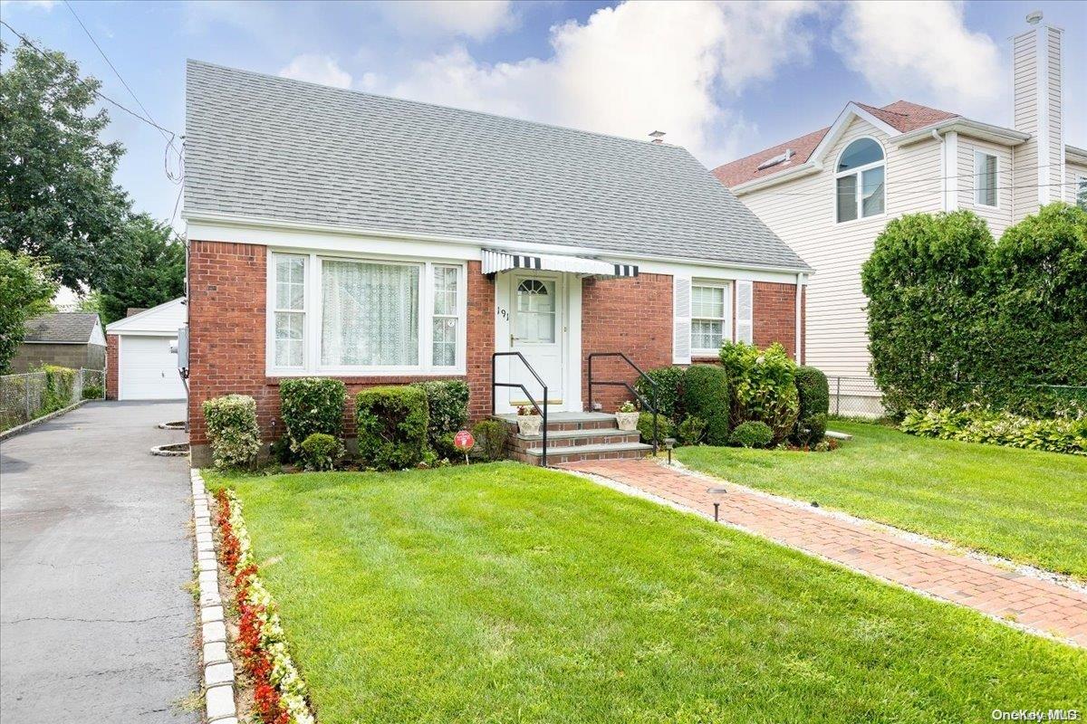 191 Roxbury Road Garden City, NY 11530 - Photo 1 of 1 a front view of a house with garden and porch