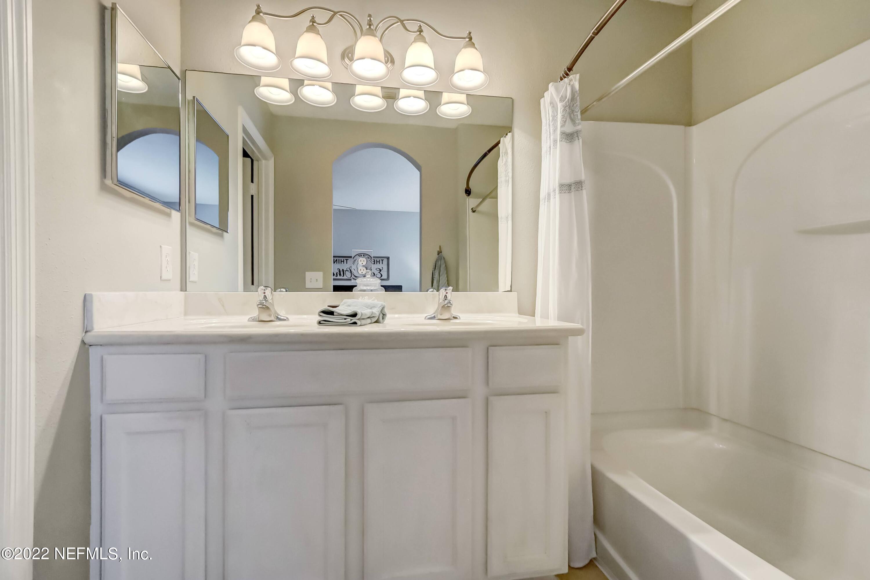 6849 Misty View Drive Jacksonville, FL 32210 - Photo 16 of 21 a bathroom with a double vanity sink and a bathtub