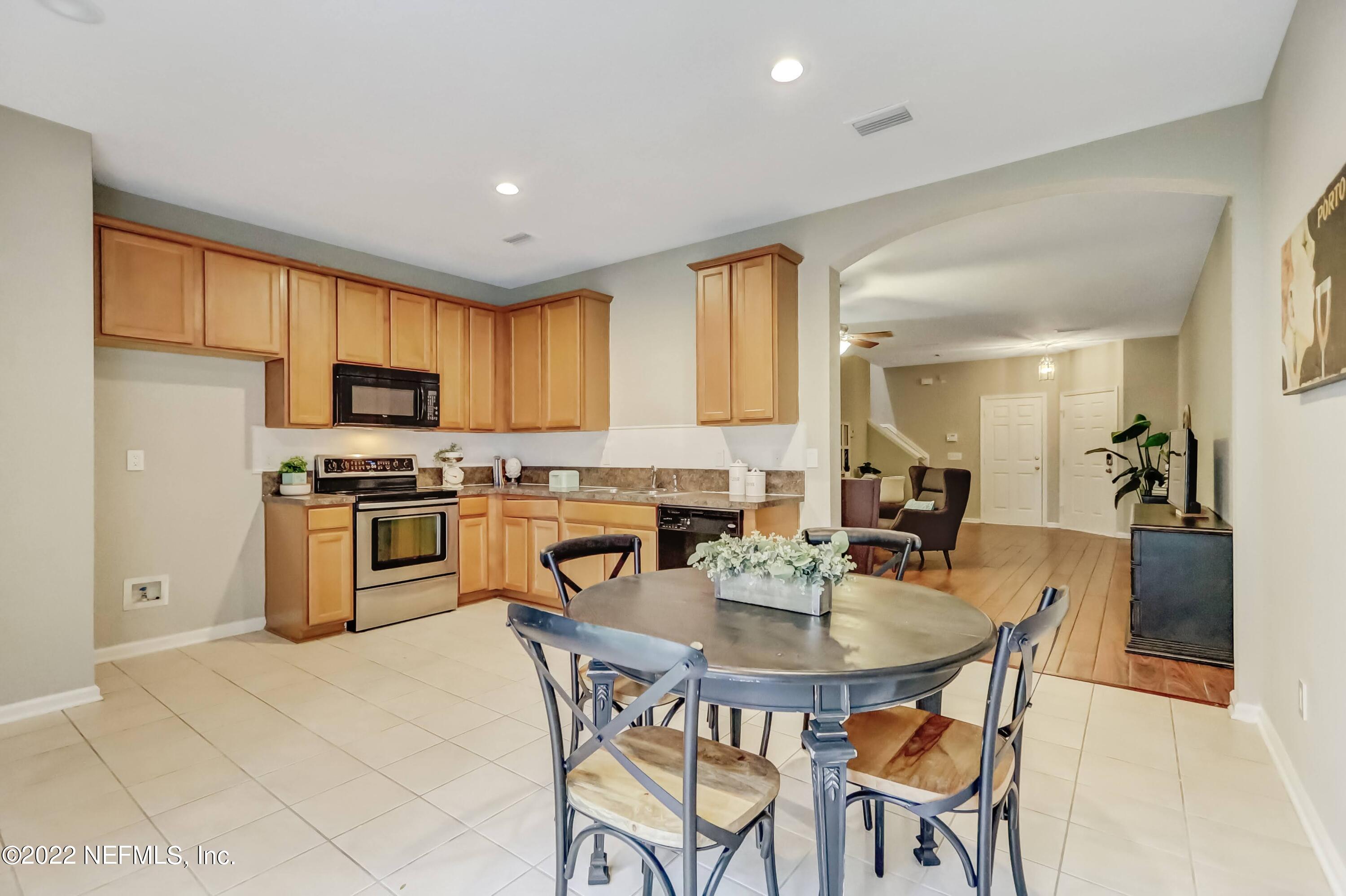 6849 Misty View Drive Jacksonville, FL 32210 - Photo 10 of 21 a kitchen with white cabinets stainless steel appliances and dining table