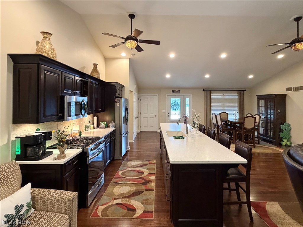 1343 Courtland Road Weirton, WV 26062 - Photo 12 of 50 Kitchen featuring ceiling fan, lofted ceiling, a breakfast bar, a spacious island, and stainless steel appliances