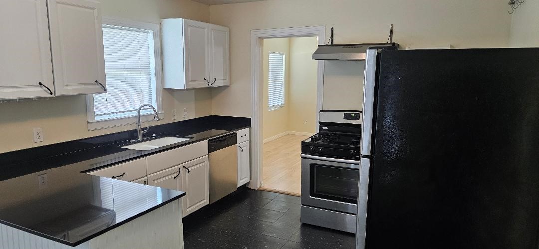 932 Walling Street Houston, TX 77009 - Photo 2 of 14 a kitchen with granite countertop stainless steel appliances and wooden cabinets