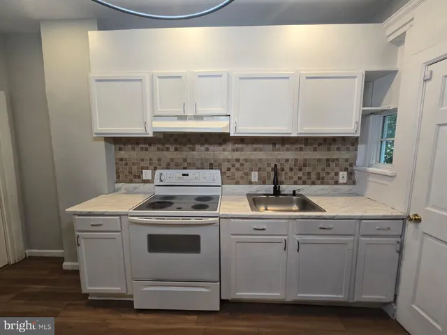 a kitchen with white cabinets and white appliances