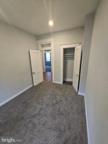 an empty room with closet and mirror
