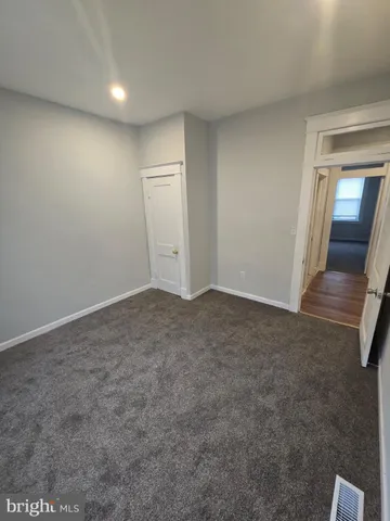 an empty room with staircase and mirror