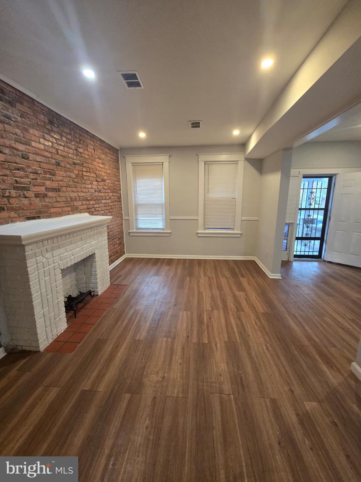 2430 Reisterstown Road Baltimore, MD 21217 - Photo 10 of 40 an empty room with wooden floor and fireplace