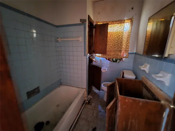 a bathroom with a tub sink and mirror