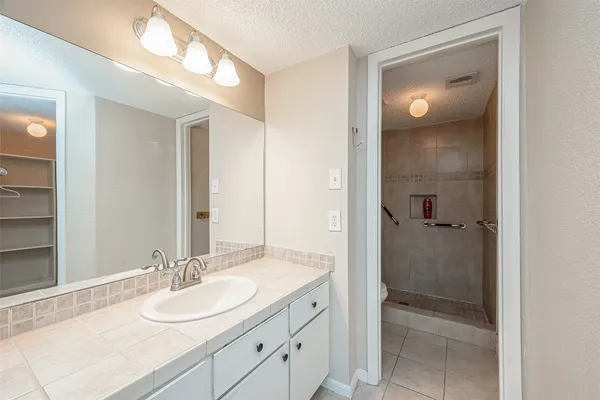 an empty room with closet and a chandelier fan
