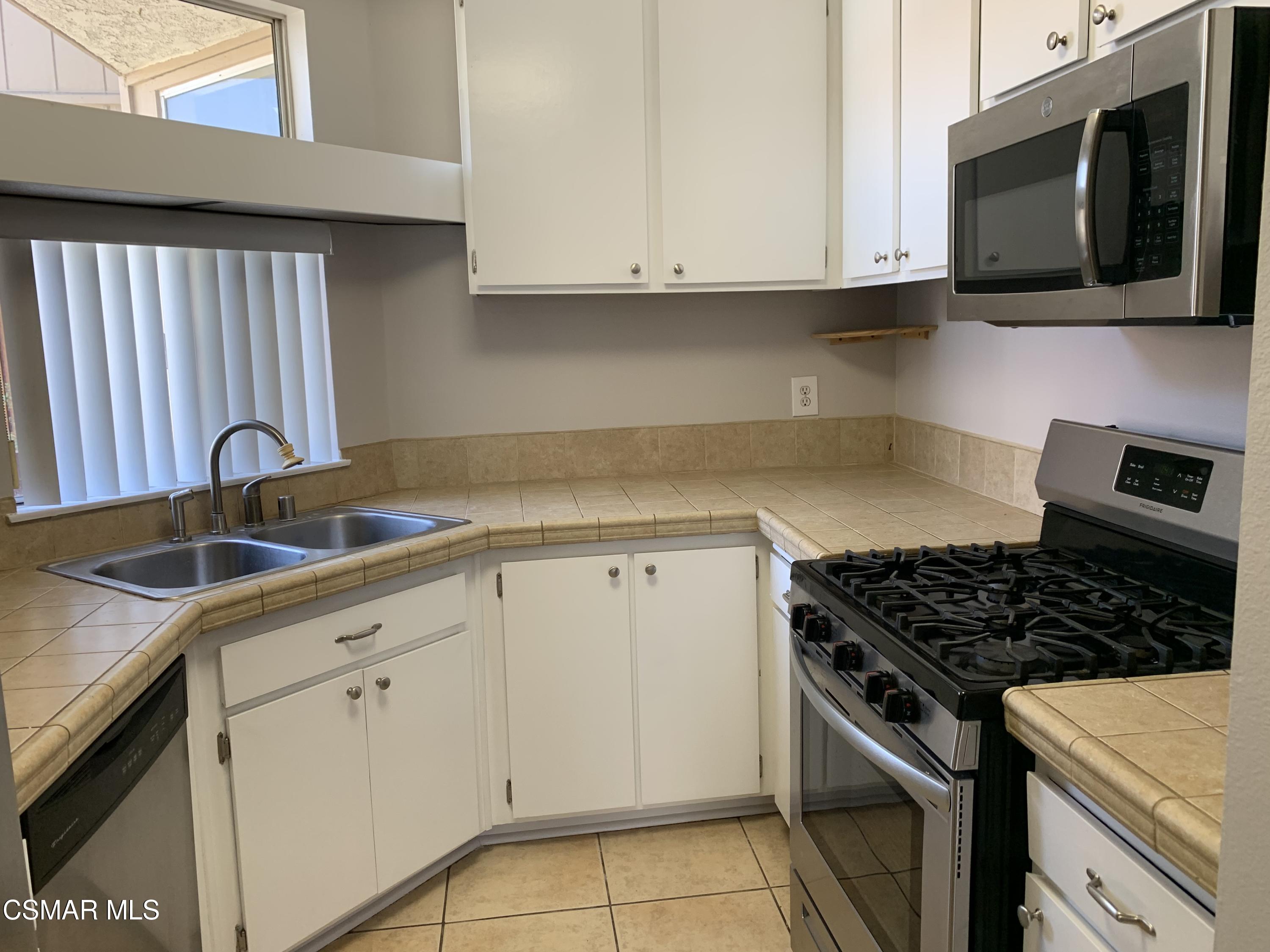1778 Sinaloa Road, Unit 298 Simi Valley, CA 93065 - Photo 14 of 43 a kitchen with granite countertop white cabinets and stainless steel appliances