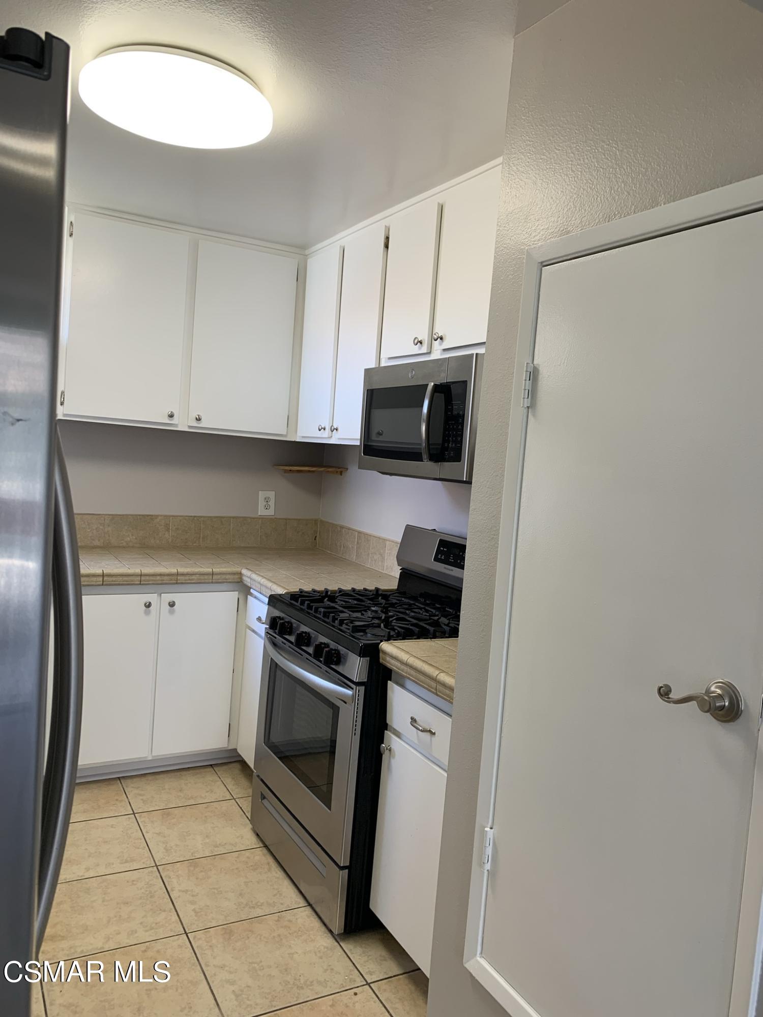 1778 Sinaloa Road, Unit 298 Simi Valley, CA 93065 - Photo 15 of 43 a kitchen with a stove a sink and a refrigerator