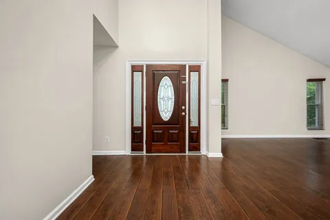 a view of a room with wooden floor and a ceiling fan