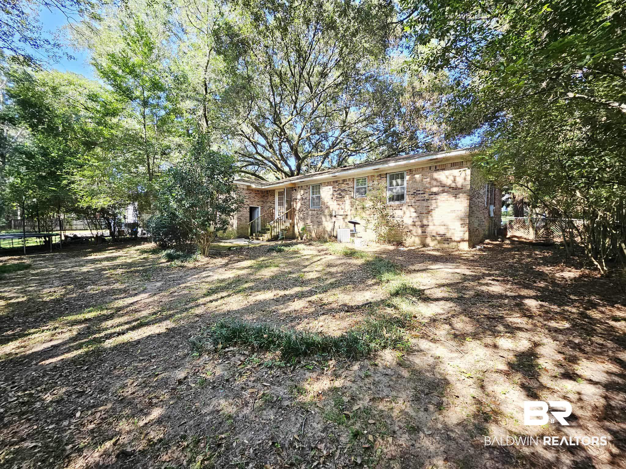 324 Vanderbilt Drive Mobile, AL 36608 - Photo 17 of 17 Back of property with brick siding and a trampoline