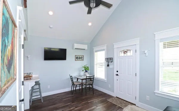 a kitchen with stainless steel appliances kitchen island granite countertop a dining table chairs and a refrigerator