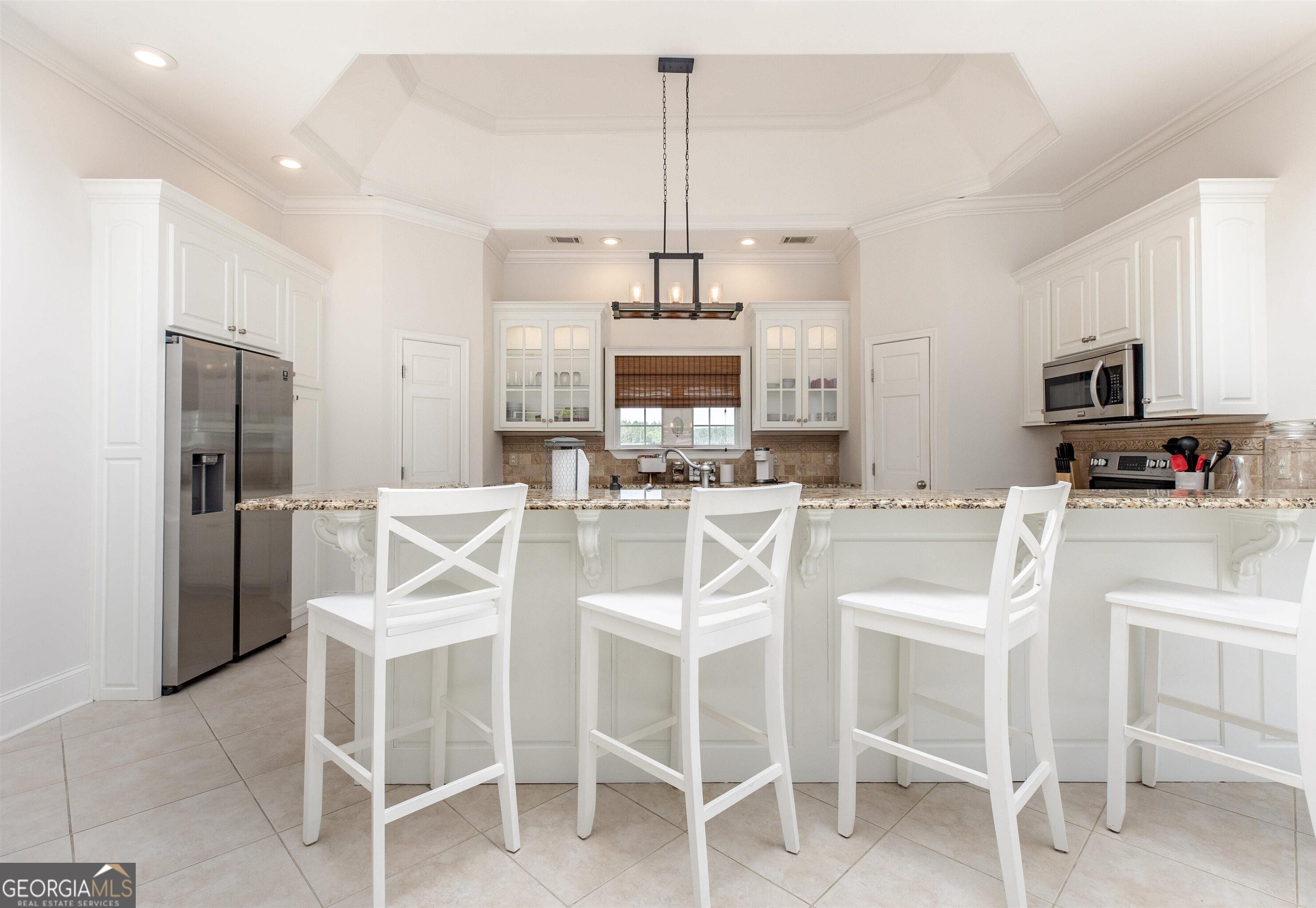 1603 Boutwell Road Perry, GA 31069 - Photo 83 of 96 a kitchen with stainless steel appliances kitchen island granite countertop a dining table chairs and a refrigerator